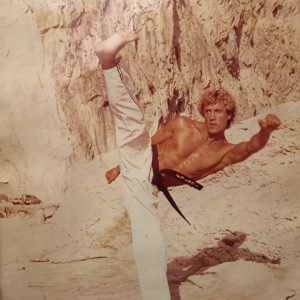 Professeur de karaté exécutant un mouvement technique dans le dojo.