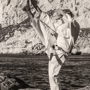 Professeur de karaté exécutant un mouvement technique dans le dojo.